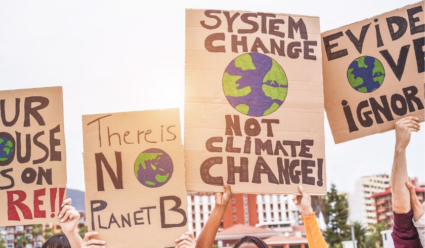 people holding billboards against climate change