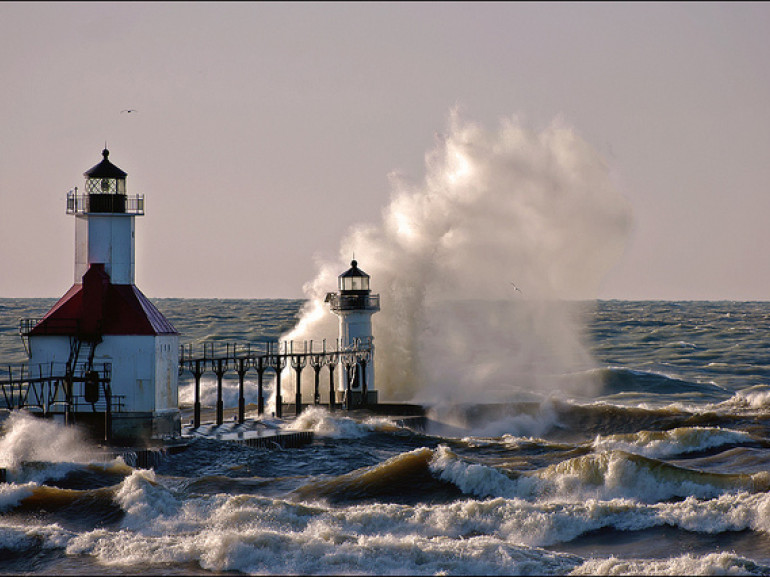 a lighthouse on the shore with waves