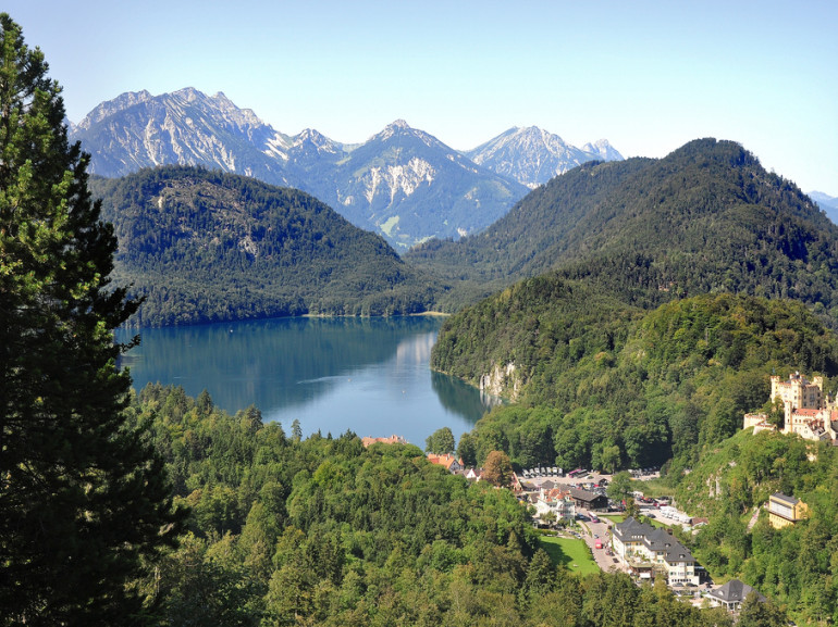 hills covered with trees surrounding a lake. Mountains on the back