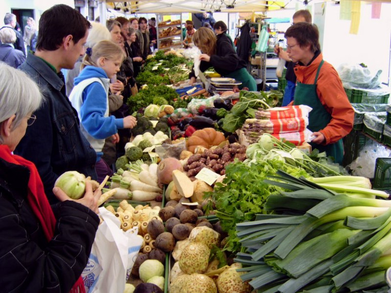 people at the market selling fresh vegetables