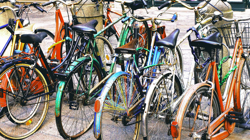 Colorful bikes parked in street in Bologna, Italy