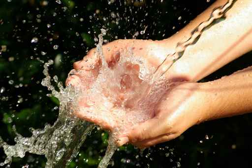 The hands receiving the water - water reuse in eco-hotels