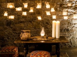 candles and wall in stones inside the Eremito Hotelito del Alma (Orvieto, TR)