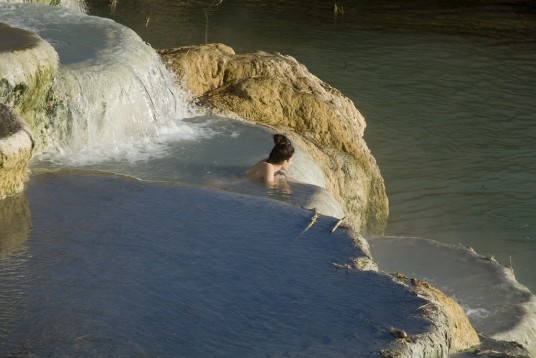 a woman lied inside the thermal pool