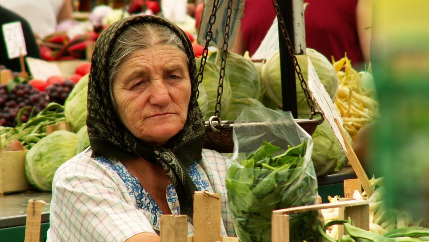 a lady at the market selling vegetables