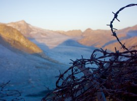 Barbed wire closeup and mountains in the background