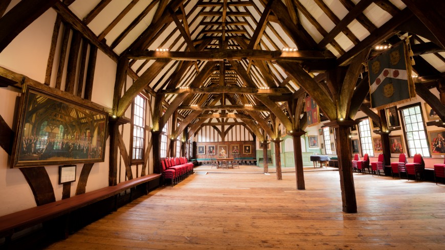 a hall made of wooden with paints and sofas