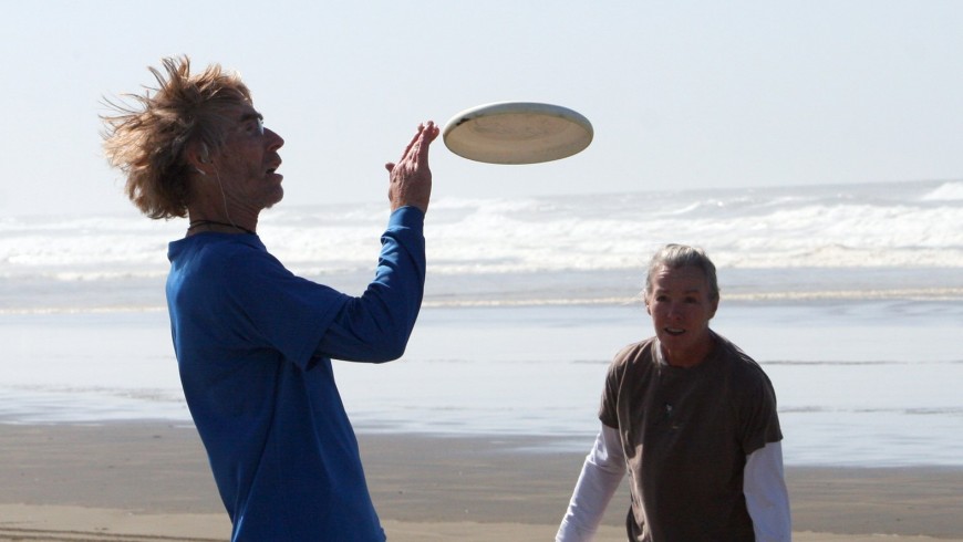 Two boys playing frisbee at the beach