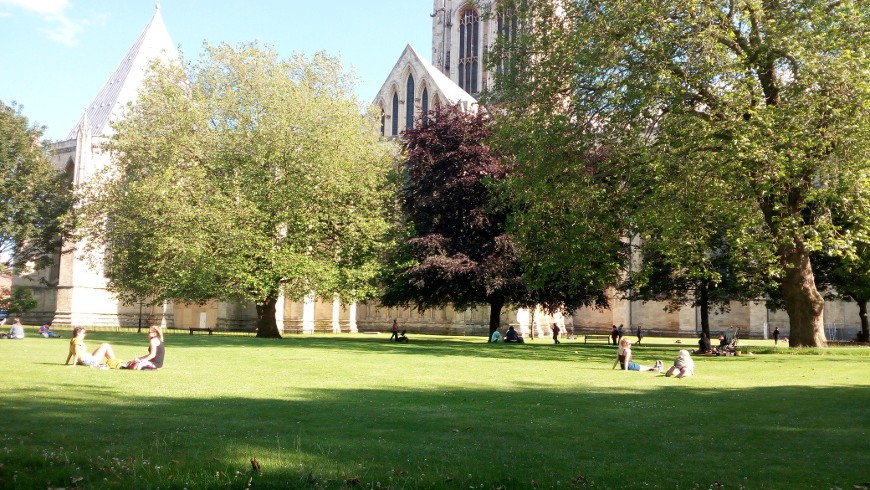 York Gardens with trees, a huge meadow and a cathedral on the background
