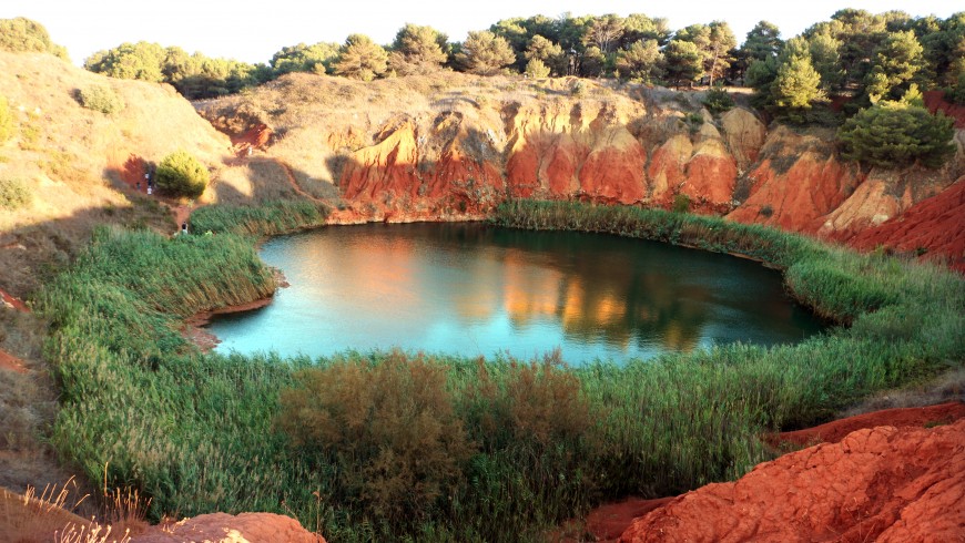 Lake of Bauxite surrounded by trees and with a green water