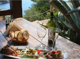 wooden table laid with local food on a balcony