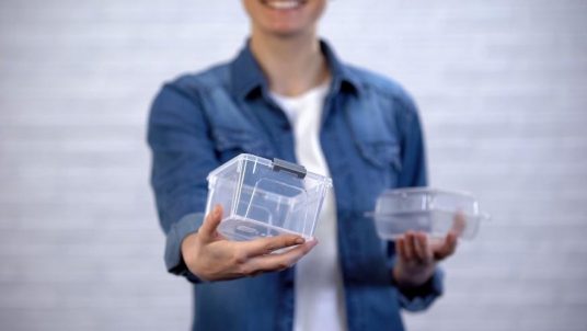 guy holding two reusable plastic containers