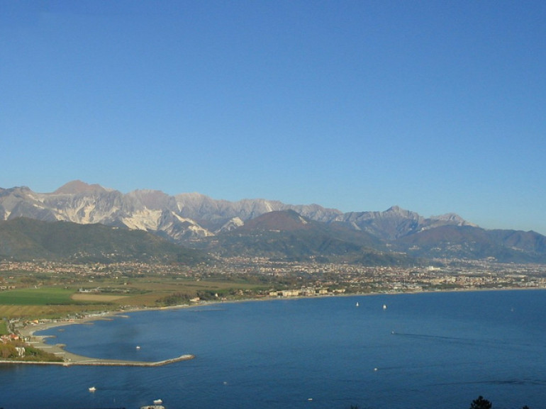 From the road that climbs to Monte Marcello lovely views over the mouth of the Magra, Ameglia Fiumaretta and Marinella of Sarzana, on the background the Apuan Alps. Photo by vengomatto via Flickr