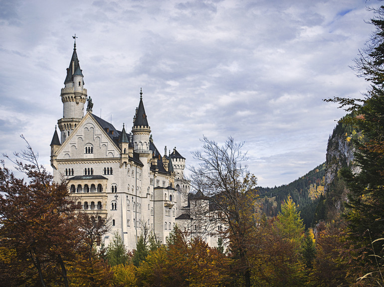 the beautiful castle with its towers on the hill surrounded by autumn trees