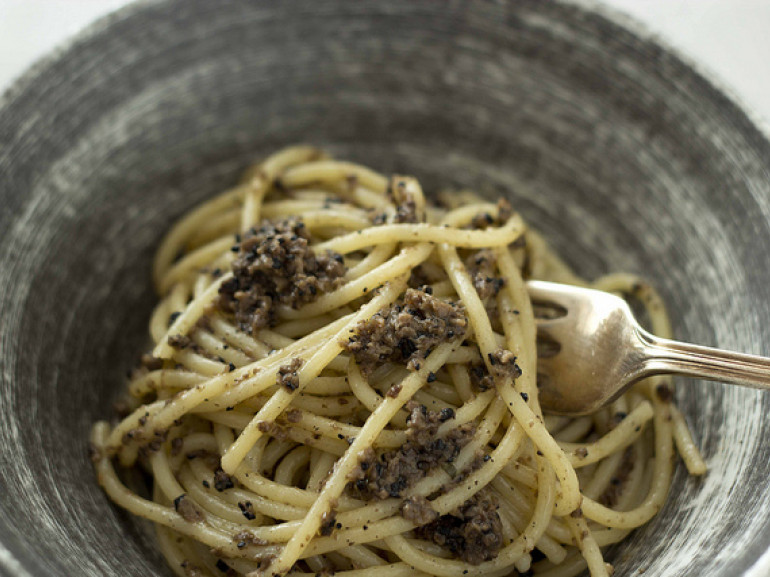 a plate of spagetti with black truffle on it