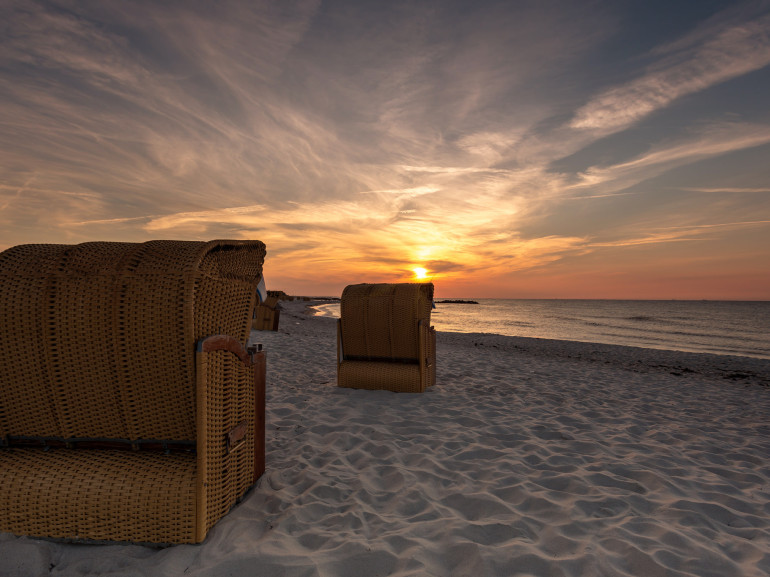 typical covered chairs on the sand in front of the sea