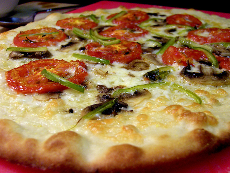 a big pizza with mozzarella, tomatoes and vegetables