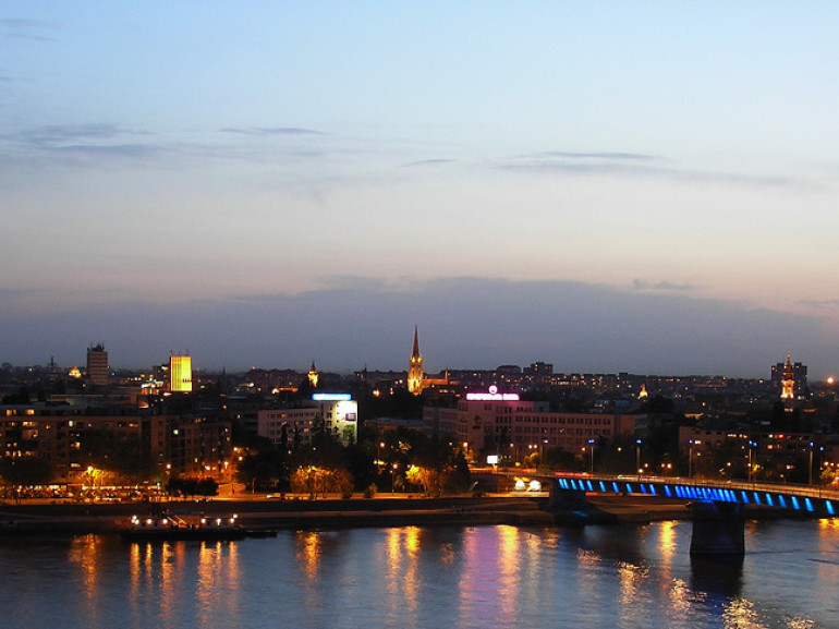 the city at night with its lights: a bridge on the river and buildings
