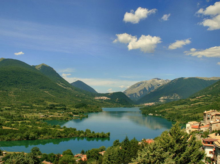 the lake surrounded by mountains and small villages