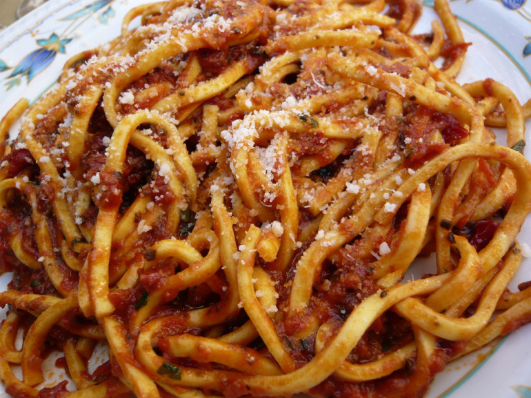 a plate with spaghetti with tomatoes sauce