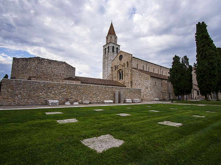 the Church and the graveyard of Aquileia surrounded by green grass