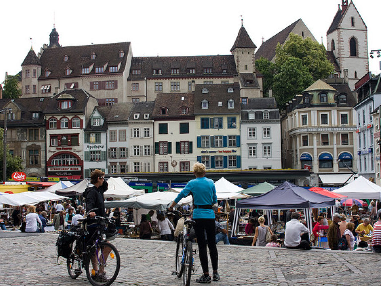 two people with a bike standing in a crowded square