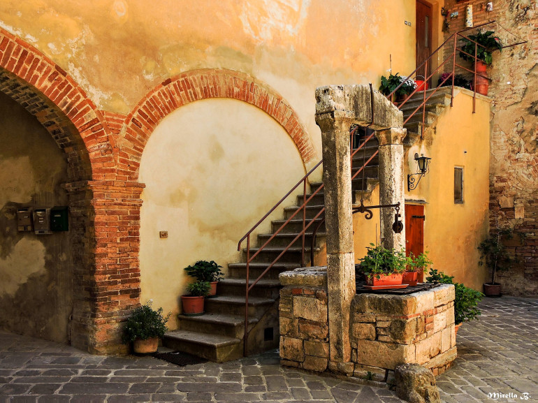 A glimpse of San Quirico d'Orcia with one of the characteristic stone fountain