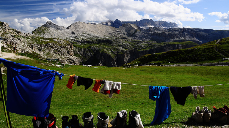 some clothes and shoes drying in the sun, mountains in the background
